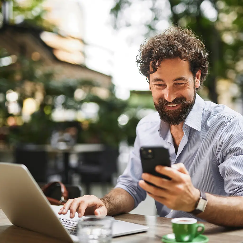 Mann mit Laptop und Smartphone